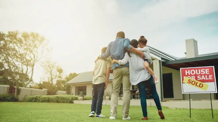 family standing outside of home they bought