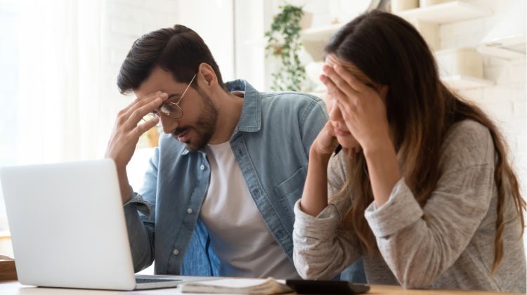 disappointed couple sitting by computer