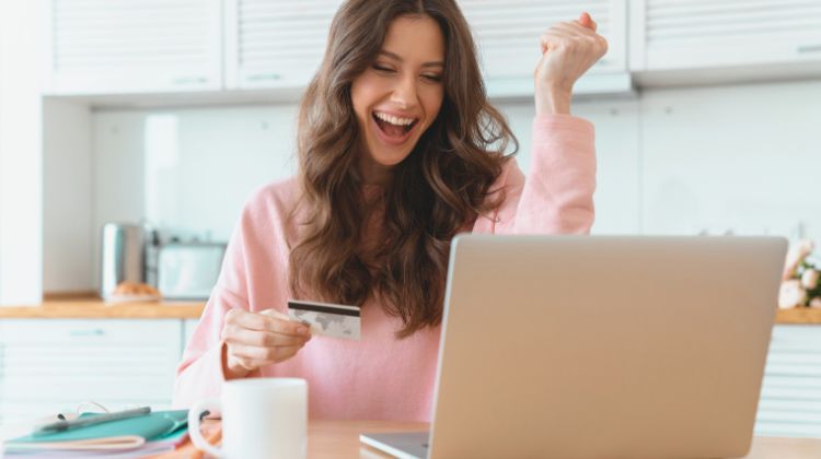 woman excited holding credit card