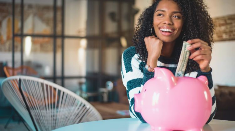 woman putting money into piggy bank