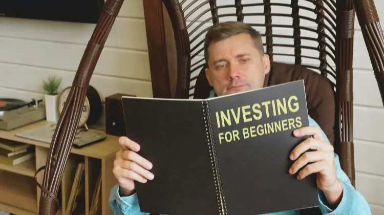 man reading a book titled "Investing for Beginners"