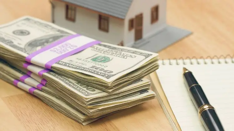 stack of money with a model house