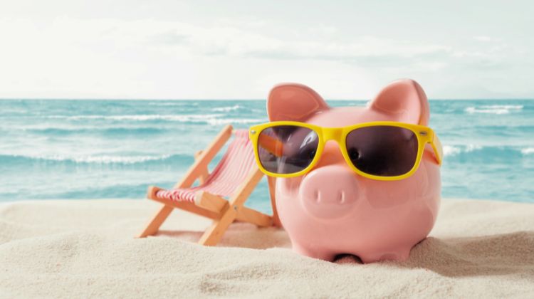 piggy bank wearing sunglasses on a beach