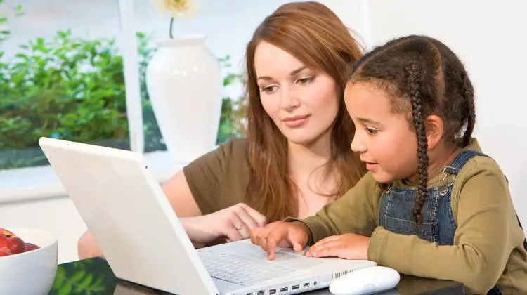 mom helping daughter at computer