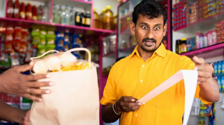 man looking at grocery bill with shock