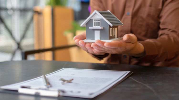 man holding a model home in hand
