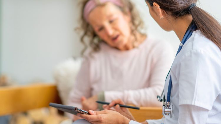 elderly woman looking over paperwork with physician