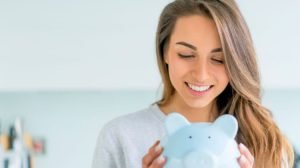 woman holding a blue piggy bank