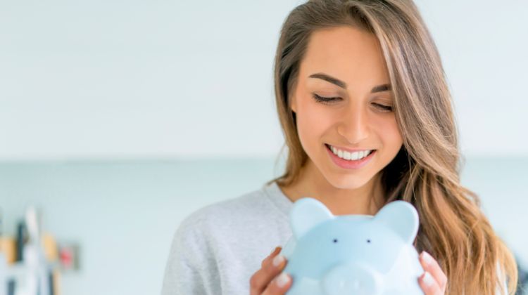 woman holding a blue piggy bank