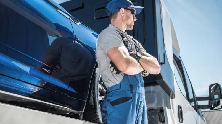 man standing next to tow truck