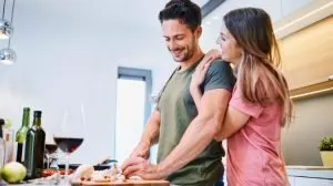 smiling couple hanging out in kitchen while cooking
