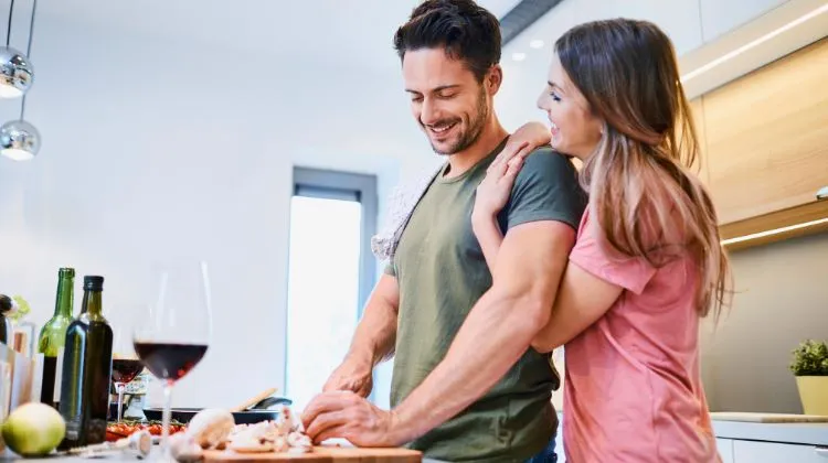 smiling couple hanging out in kitchen while cooking