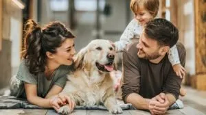 young family laying down on the floor with family dog