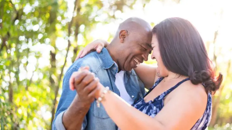 happy middle aged couple dancing together outside